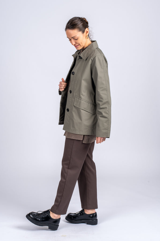 Klasikinis oversized tipo švakelis/striukė camel spalvos, vidutinio ilgio, subtiliai maskuoja sėkmenis ir suteikia kasdieniai išvaizdai modernios klasikos įvaizdį, nuotraukoje modelis iš šono, matoma detalė - priekinės kišenės