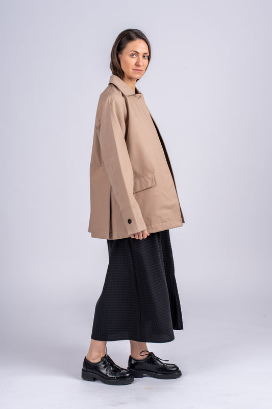 Šviesiai rudos spalvos minimalistinio dizaino moteriškas švarkas/striukė elegantišku tiesiu siluetu, užsagstoma kniedėmis, nuotraukoje modelis su atsegtu švarku iš šono