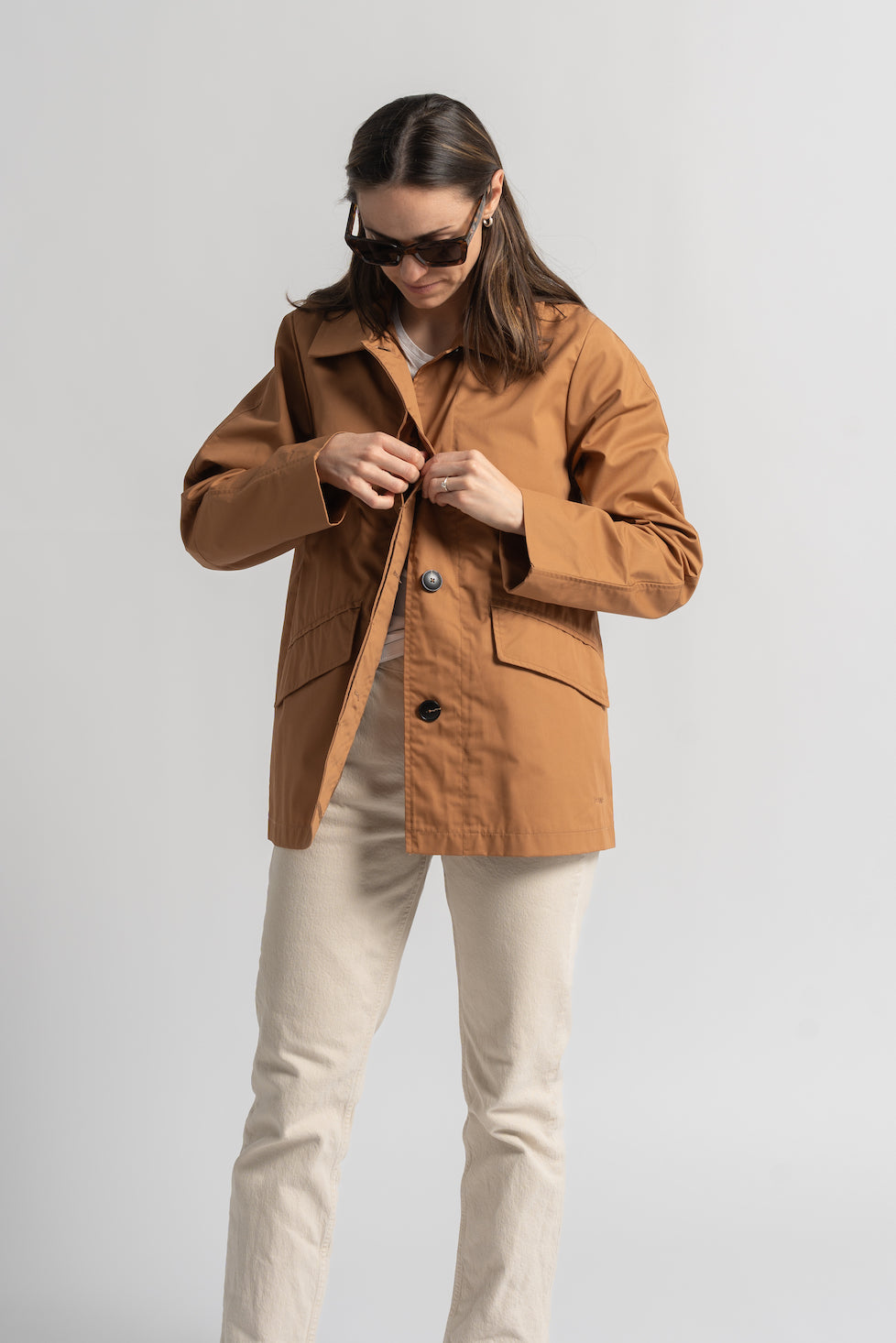 Klasikinis oversized tipo švakelis/striukė camel spalvos, vidutinio ilgio, subtiliai maskuoja sėkmenis ir suteikia kasdieniai išvaizdai modernios klasikos įvaizdį, nuotraukoje modelis iš priekio, matosi u-segimas sagomis